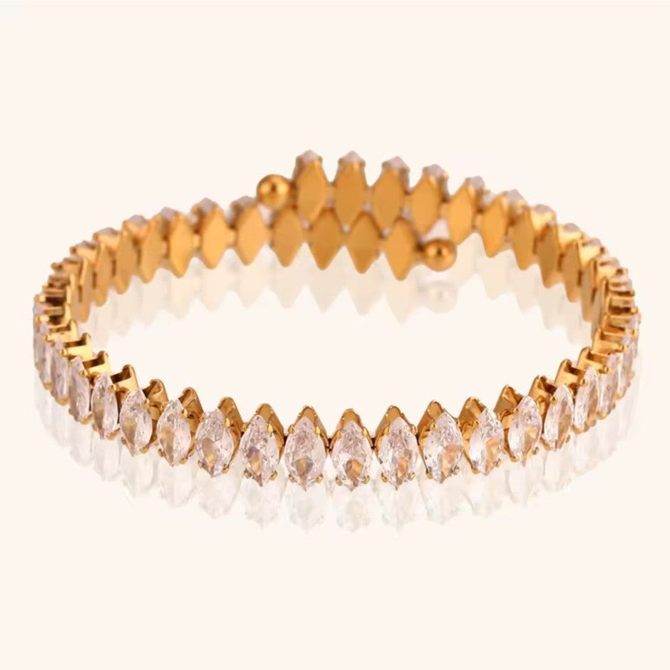 Gold bracelet with clear stones on a white background