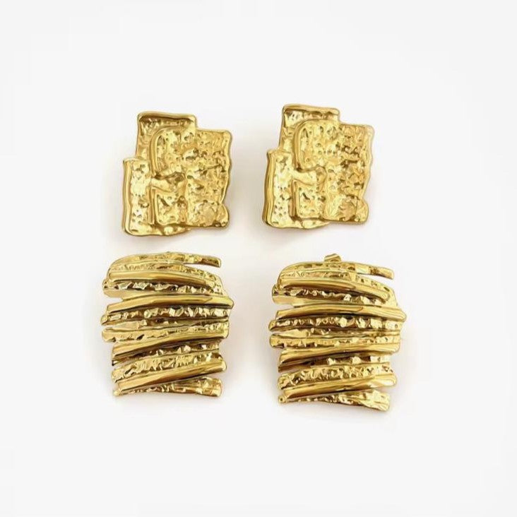 Pair of gold textured earrings on a white background