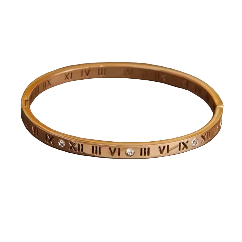 A Roman Style Stainless Steel Classic Bangle – Gold colored with white stones on a neutral background.