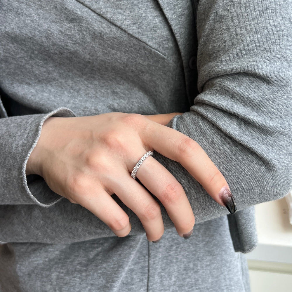 A silver band eternity ring with round-cut cubic zirconia stones set around its entire circumference.
