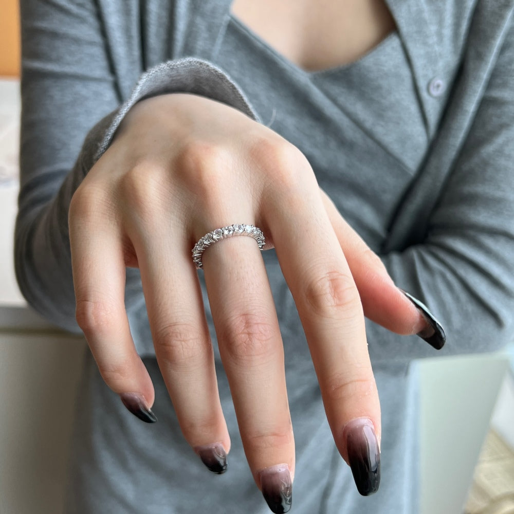 A silver band eternity ring with round-cut cubic zirconia stones set around its entire circumference.