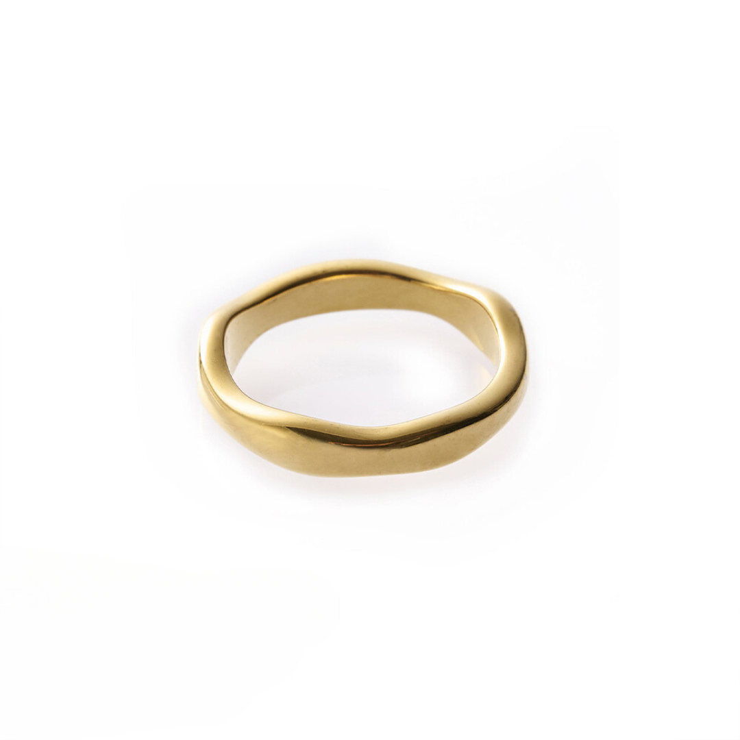 A gold-colored band ring with a wavy design, made from stainless steel, displayed on a plain background.