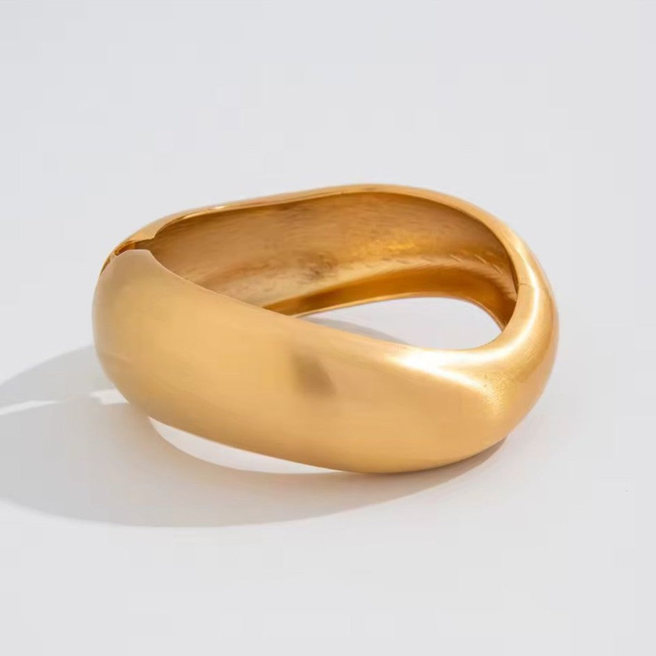 Gold Bangle on a light gray background
