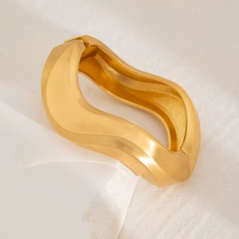 Gold Bangle on a white fabric background