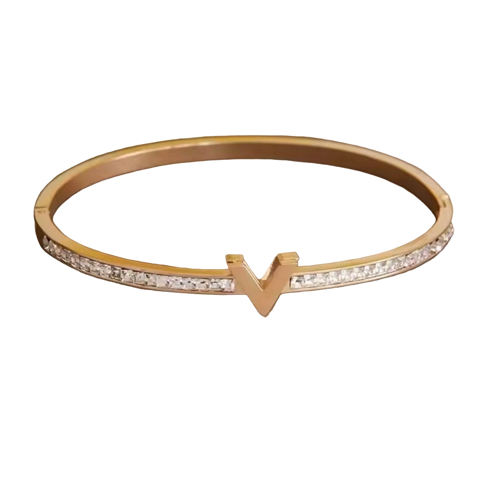 A gold stainless steel bracelet featuring a V-shaped pattern of inset stones, showcasing a sophisticated and elegant design.