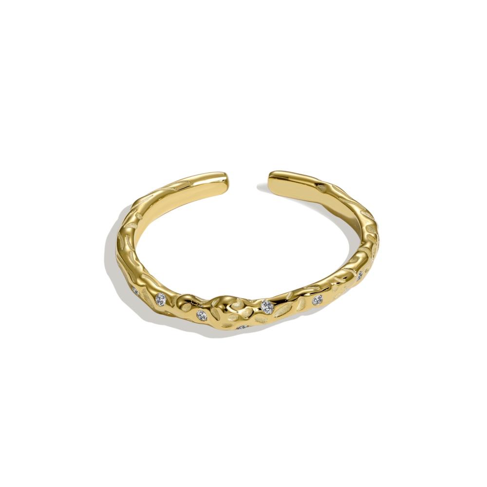 A gold-colored adjustable ring with a textured surface and embedded transparent stones.