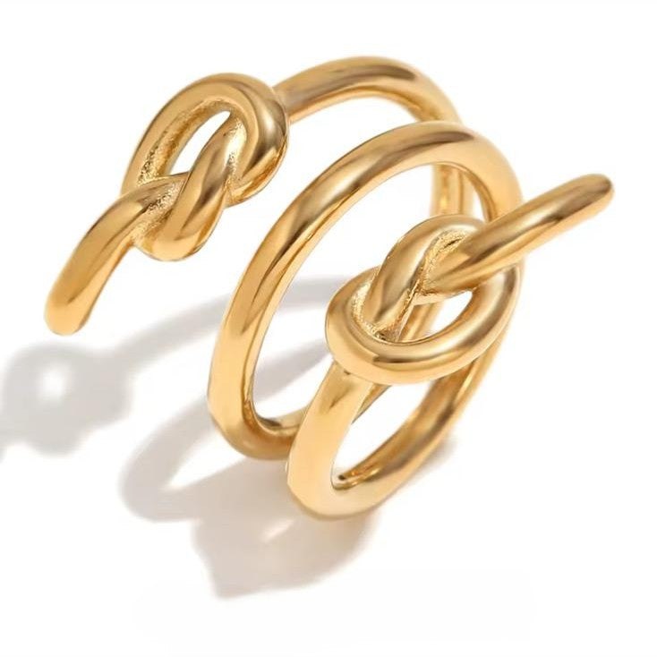 Gold three-knot-shaped ring on a white background