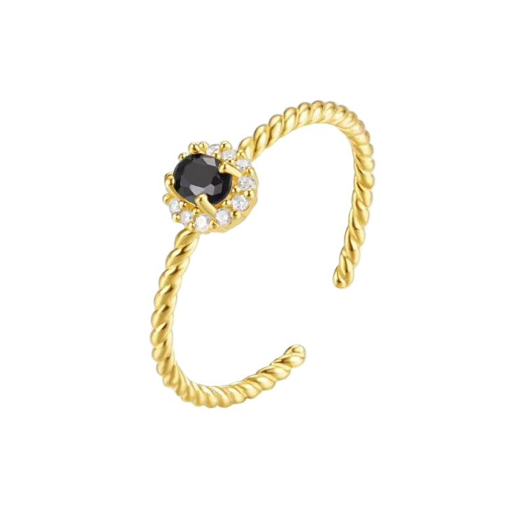 A Twisted Gold open ring with a black gemstone and small diamonds on a white background