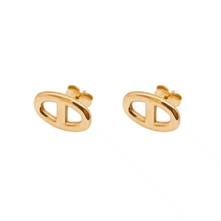 Gold earrings on a light beige background