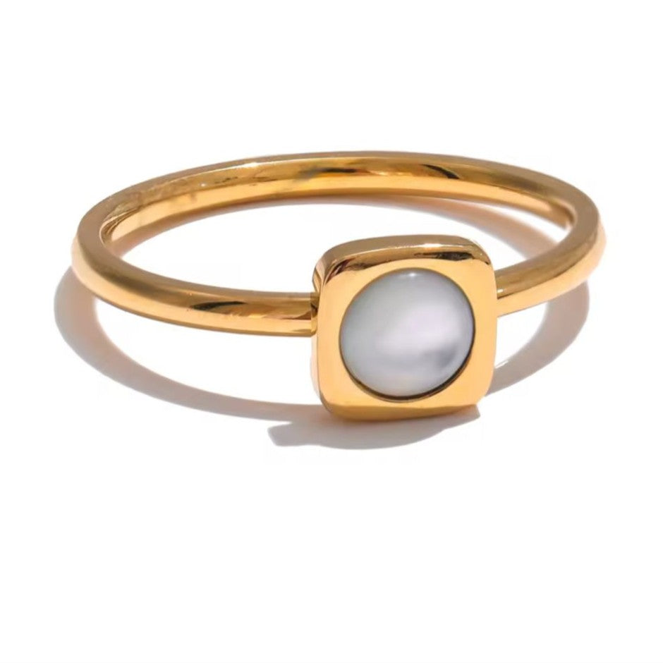 Gold ring with a central gemstone on a white background