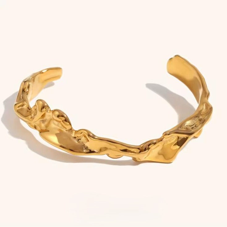 Wrinkle Gold bracelet made of stainless steel on a plain background