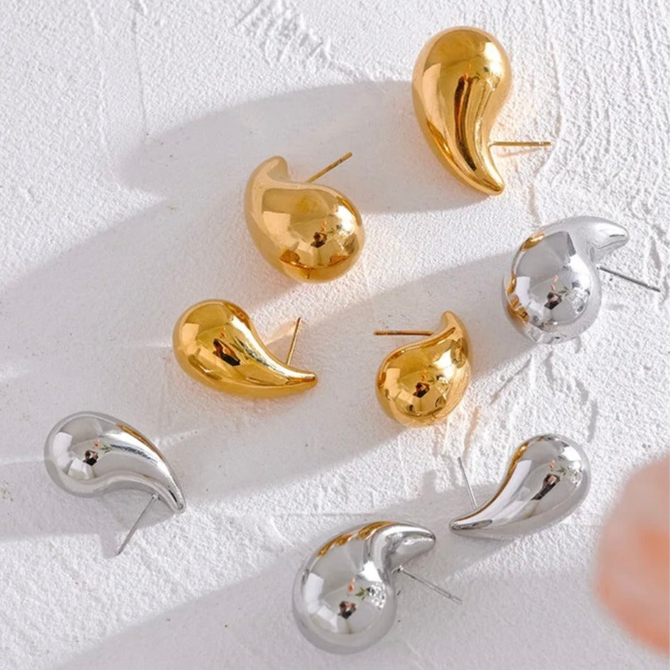 A set of gold & silver-colored drop earrings with a glossy finish.