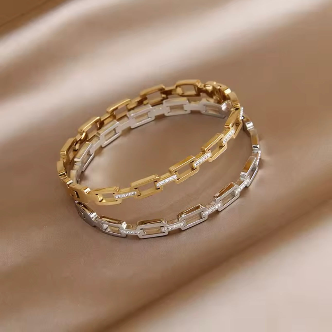 Silver & Gold chain bracelets with diamond accents on a beige background