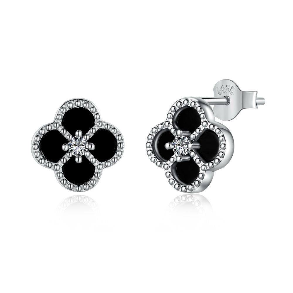 A pair of clover-shaped stud earrings with black and white stones set in a rhodium-plated 925 sterling silver band.