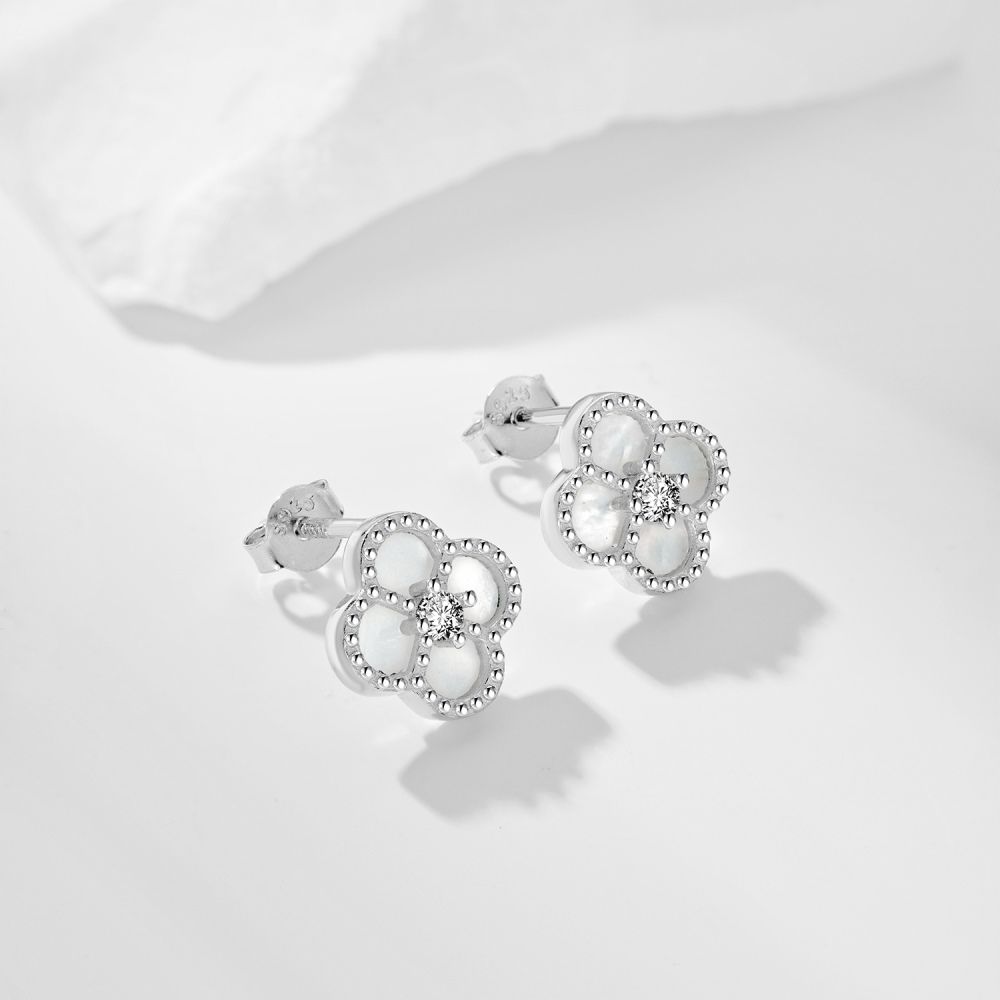 A pair of clover-shaped stud earrings with white stones set in a rhodium-plated 925 sterling silver band.