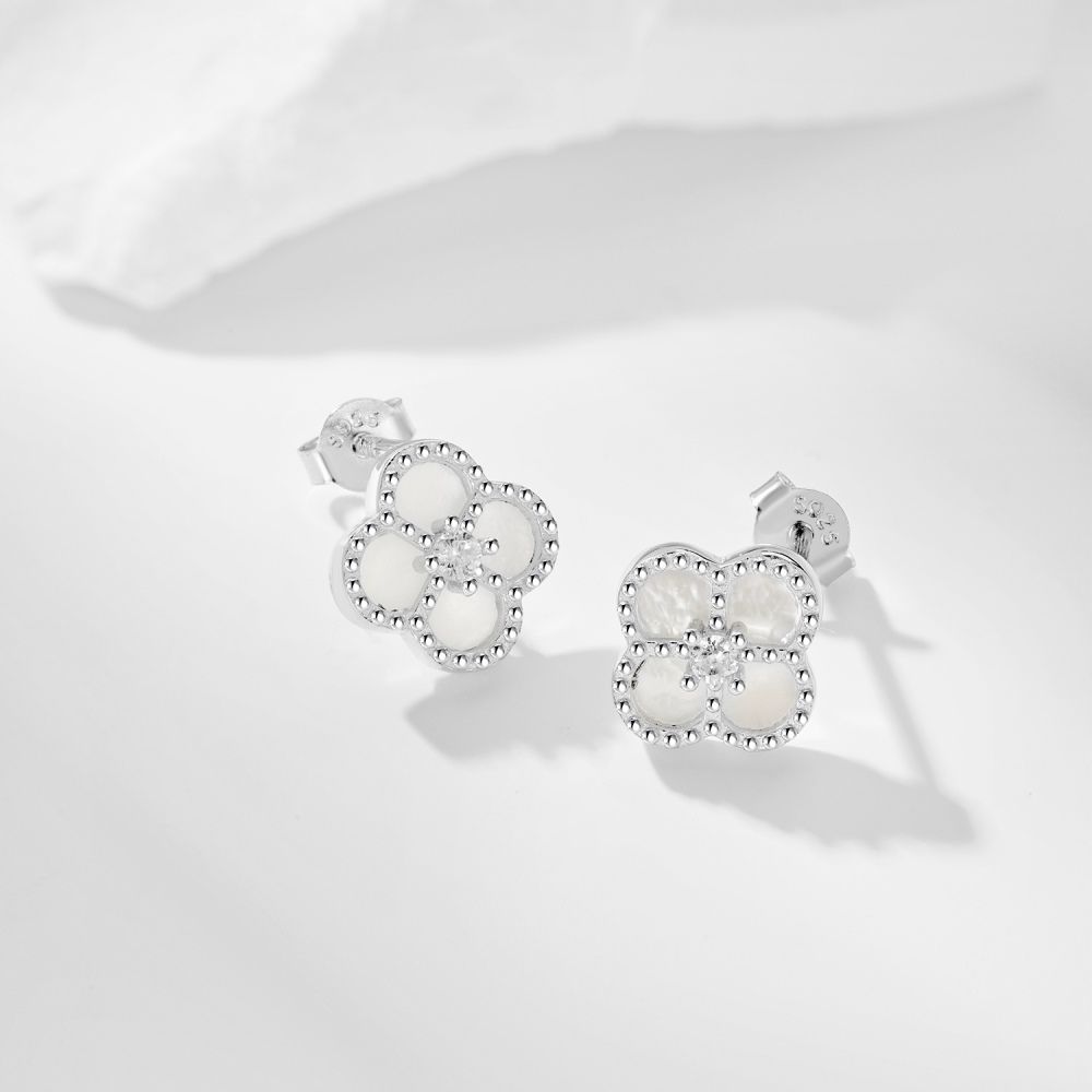 A pair of clover-shaped stud earrings with white stones set in a rhodium-plated 925 sterling silver band.