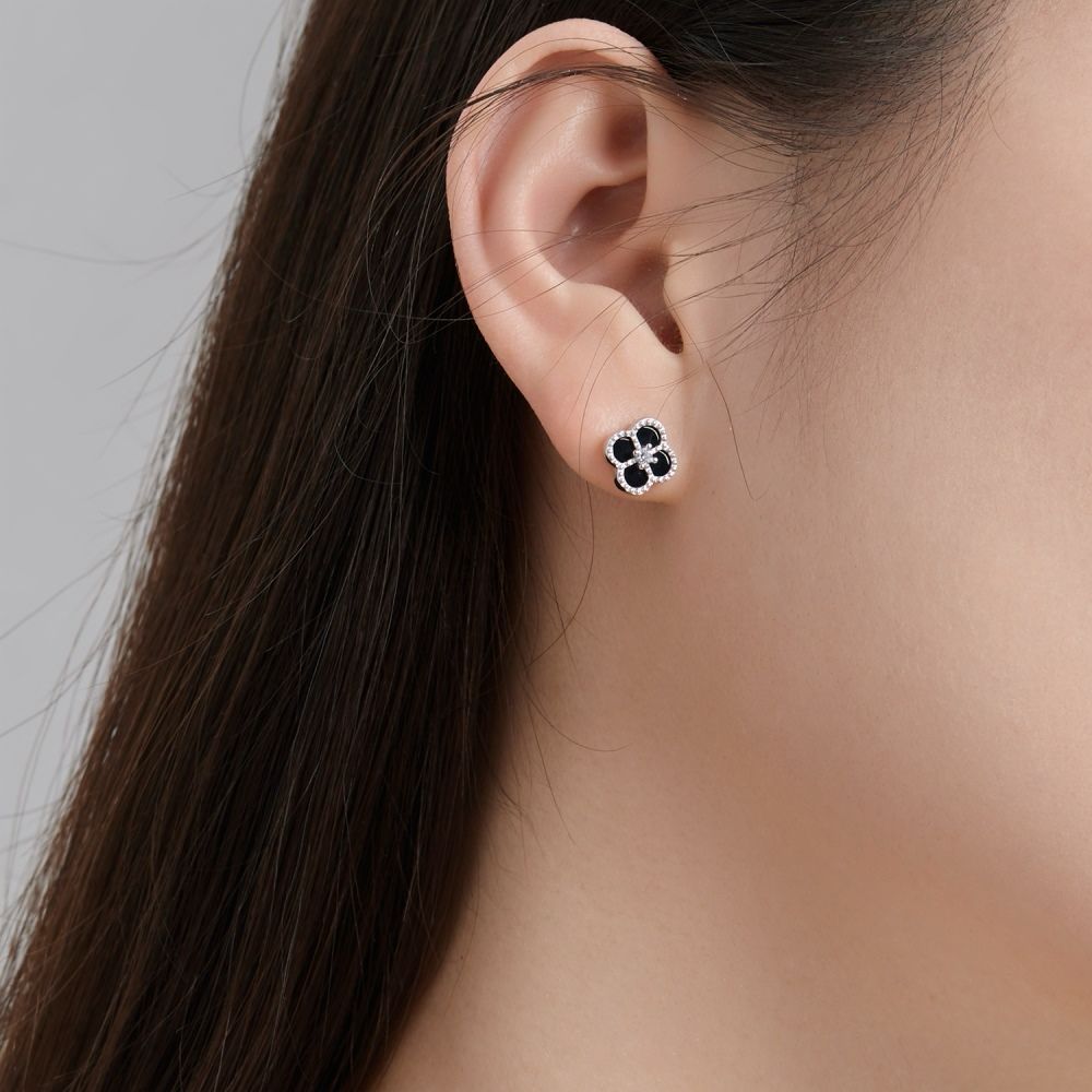 A clover-shaped stud earring with black and white stones in a rhodium-plated 925 sterling silver band.