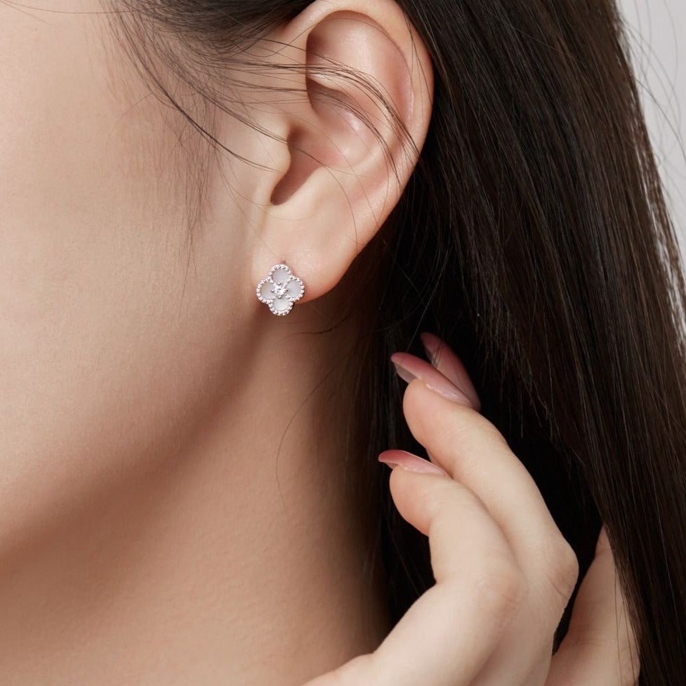 A clover-shaped stud earring with white stones in a rhodium-plated 925 sterling silver band.