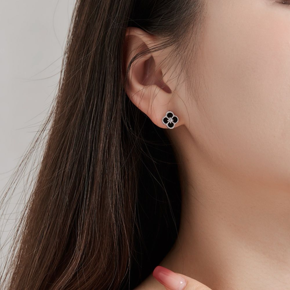 A clover-shaped stud earring with black and white stones in a rhodium-plated 925 sterling silver band.