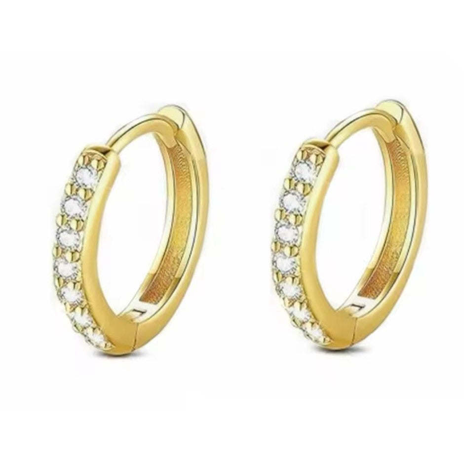 A pair of stainless steel huggie hoop earrings with crystals adorning the band.