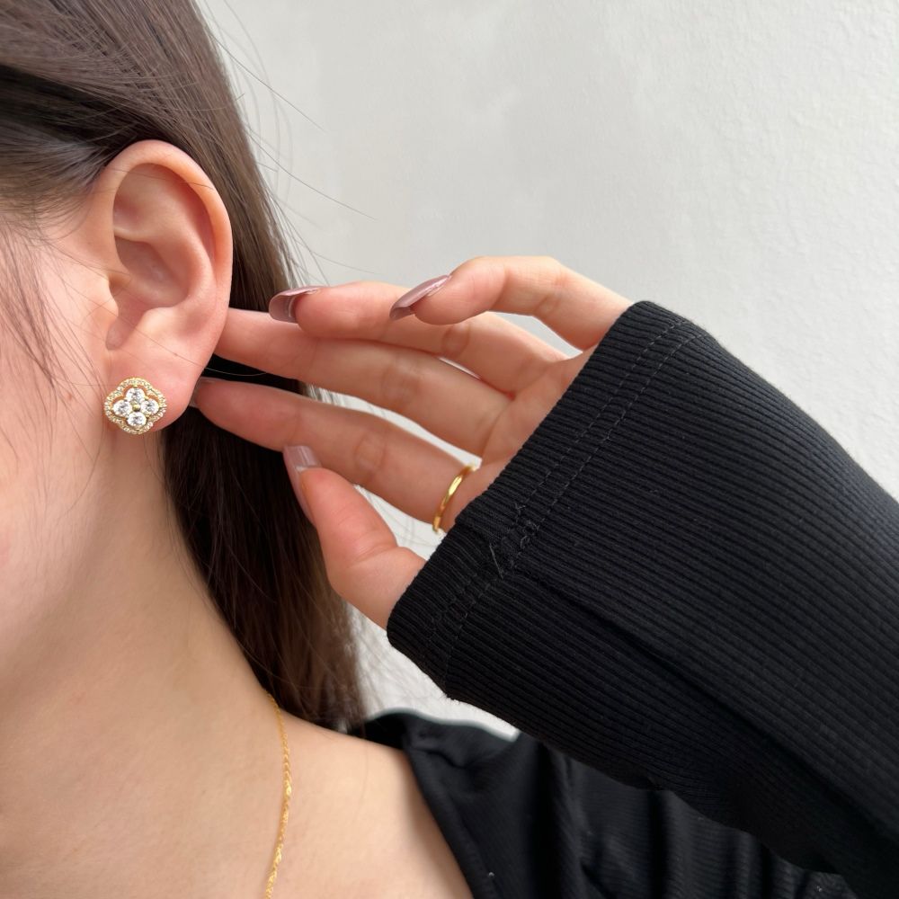 A gold-plated sterling silver clover stud earring with multiple cubic zirconia stones.
