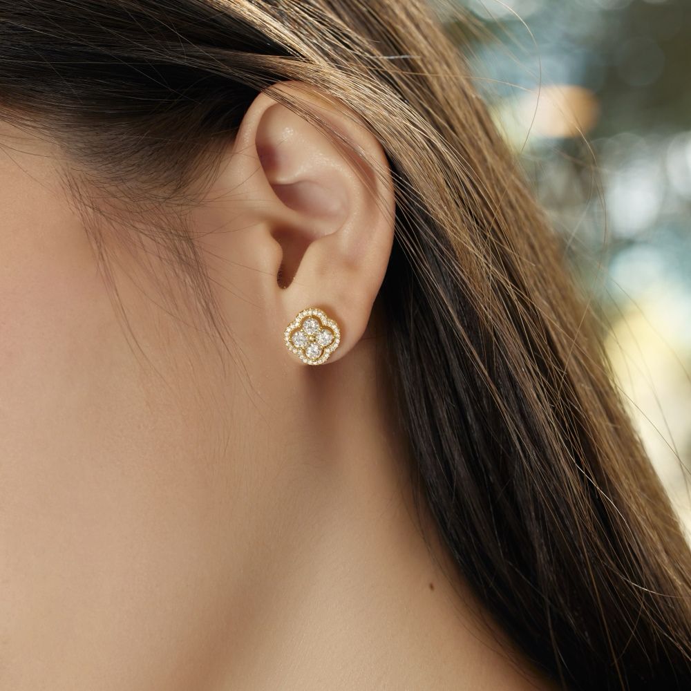 A gold-plated sterling silver clover stud earring with multiple cubic zirconia stones.