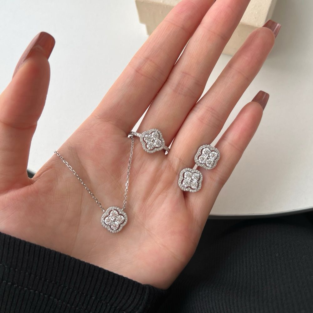 A pair of gold-plated sterling silver clover stud earring, necklace and ring with multiple cubic zirconia stones.
