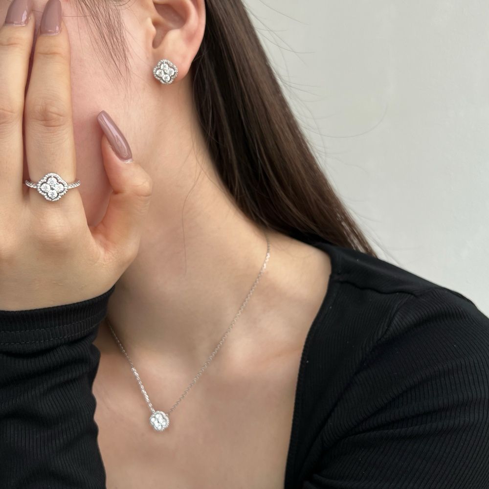 A gold-plated sterling silver clover stud earring, ring and necklace with multiple cubic zirconia stones.