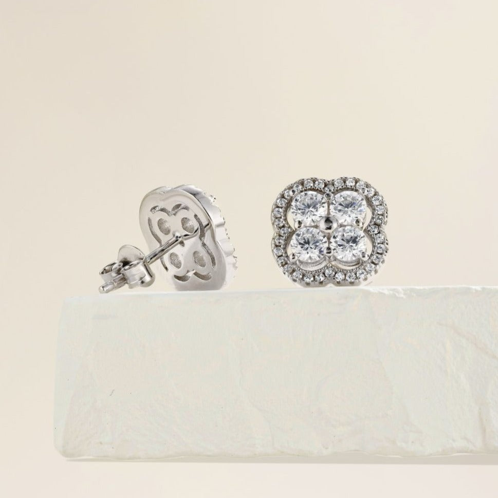 A pair of gold-plated sterling silver clover stud earrings with multiple cubic zirconia stones.