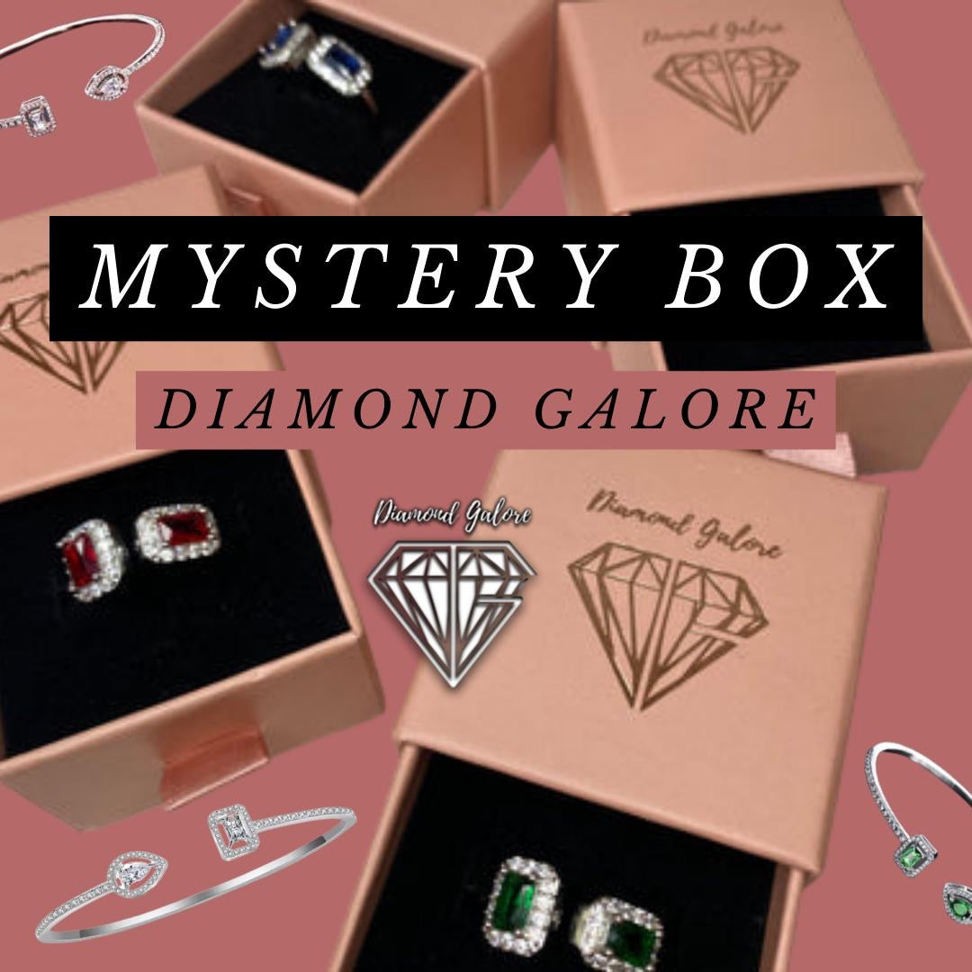 A collection of jewellery items including rings and earrings displayed in front of boxes labelled 'Mystery Box Diamond Galore'.