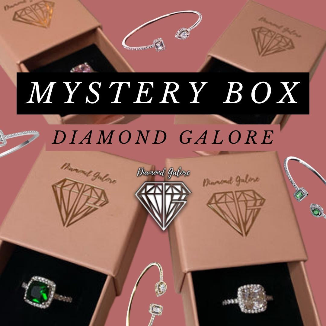 A collection of jewellery items including rings, displayed on a table with 'Mystery Box' text overlay and the 'Diamond Galore' brand logo.