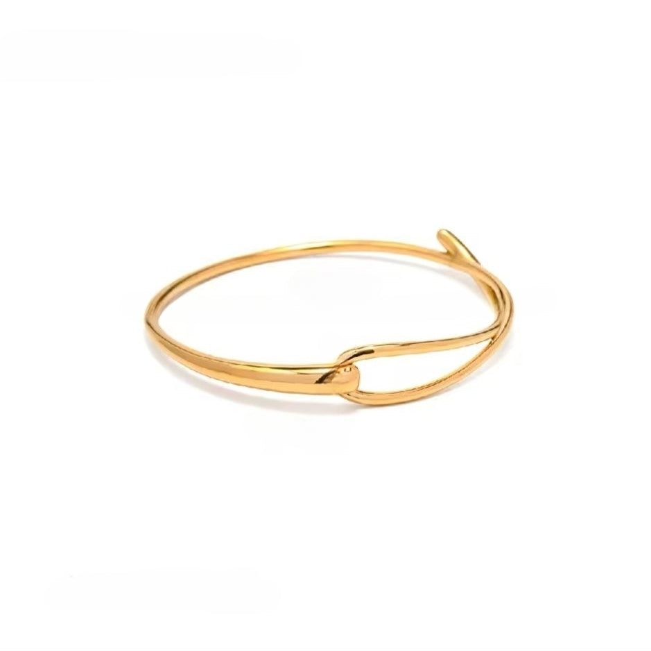 A gold-colored bangle/bracelet with a intertwined design on a white background.