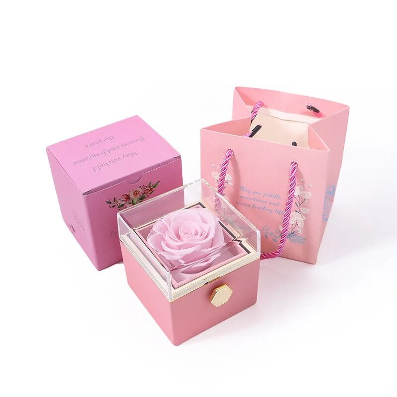 Rotatable gift box with a preserved pink rose inside, displayed alongside its packaging boxes.