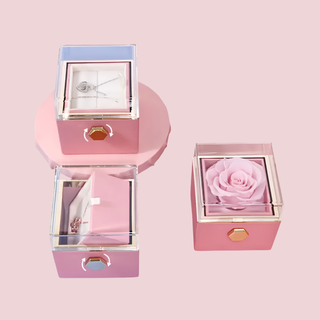 Rotatable gift box with a preserved pink rose inside, displayed alongside its packaging box and necklace boxes.