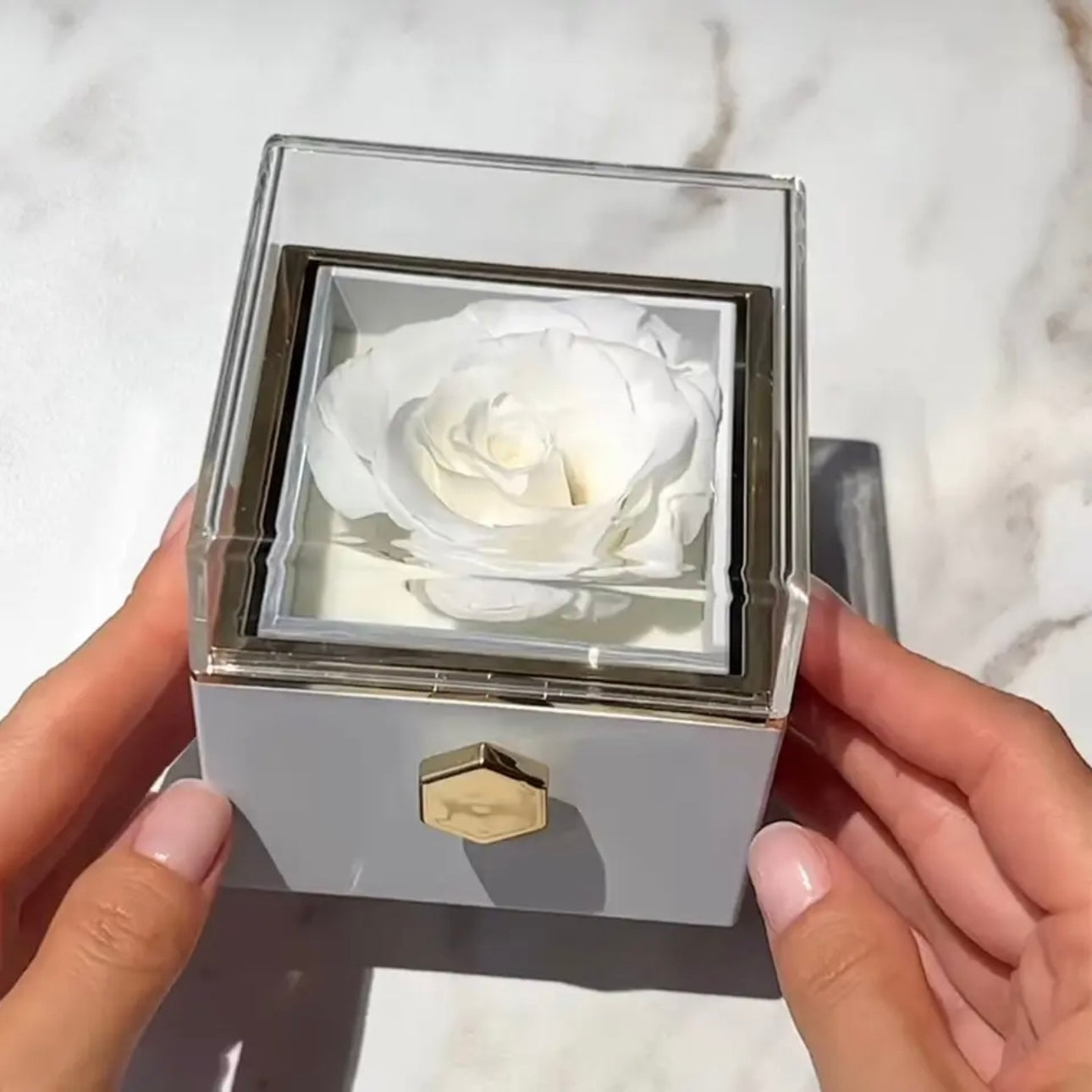 Rotatable gift box with a preserved white rose inside, displayed over a white surface.