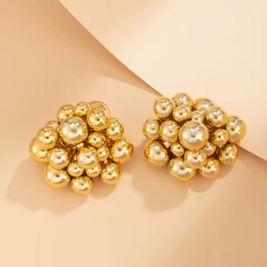 A pair of gold-colored earrings with a honeycomb pattern.