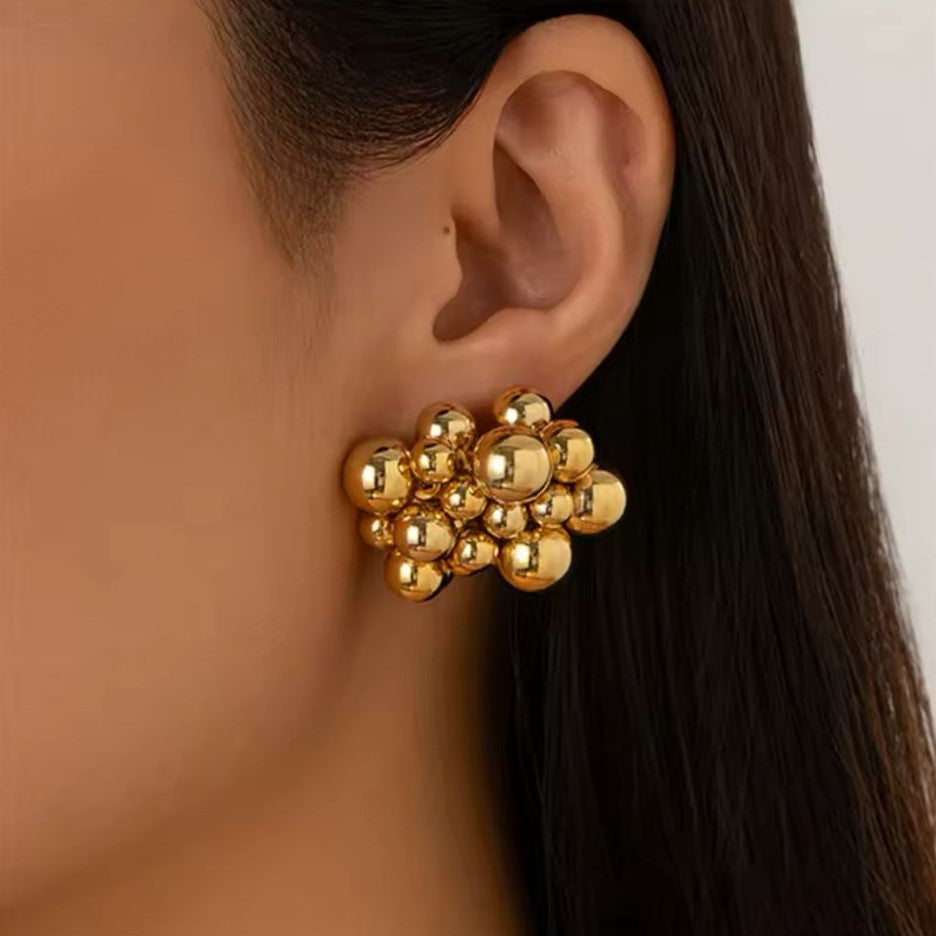A premium quality Honeycomb style Gold Earring presented on a women's ear.