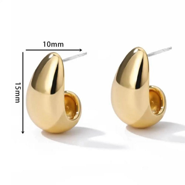 A pair of gold-colored, curved hoop earrings on a white background.