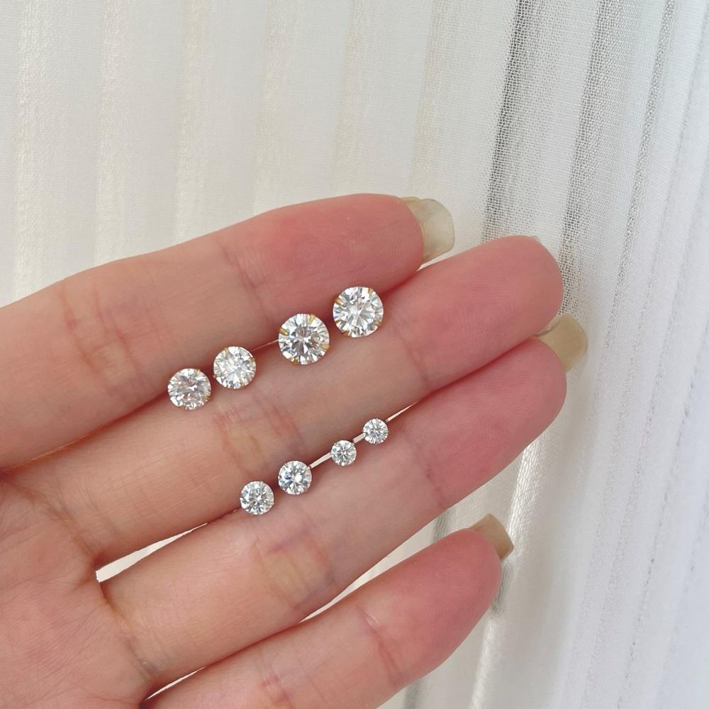 Four sets of gold-plated barbell stud earrings featuring clear, faceted gemstones.