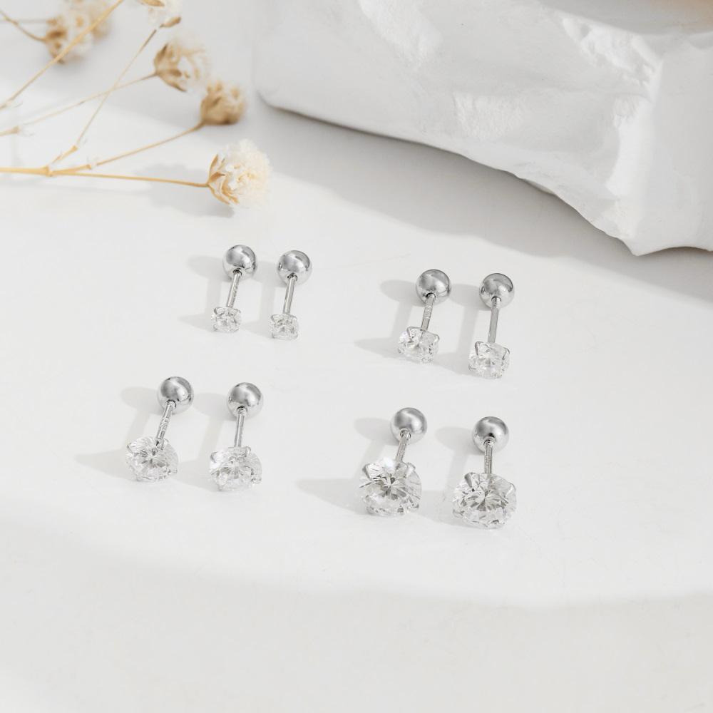 Four pairs of gold-plated barbell stud earrings featuring a clear, faceted gemstone on the end.