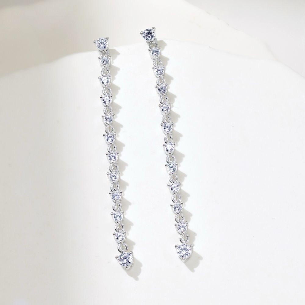 A pair of long drop earrings featuring a series of clear cubic zirconia stones set in sterling silver.