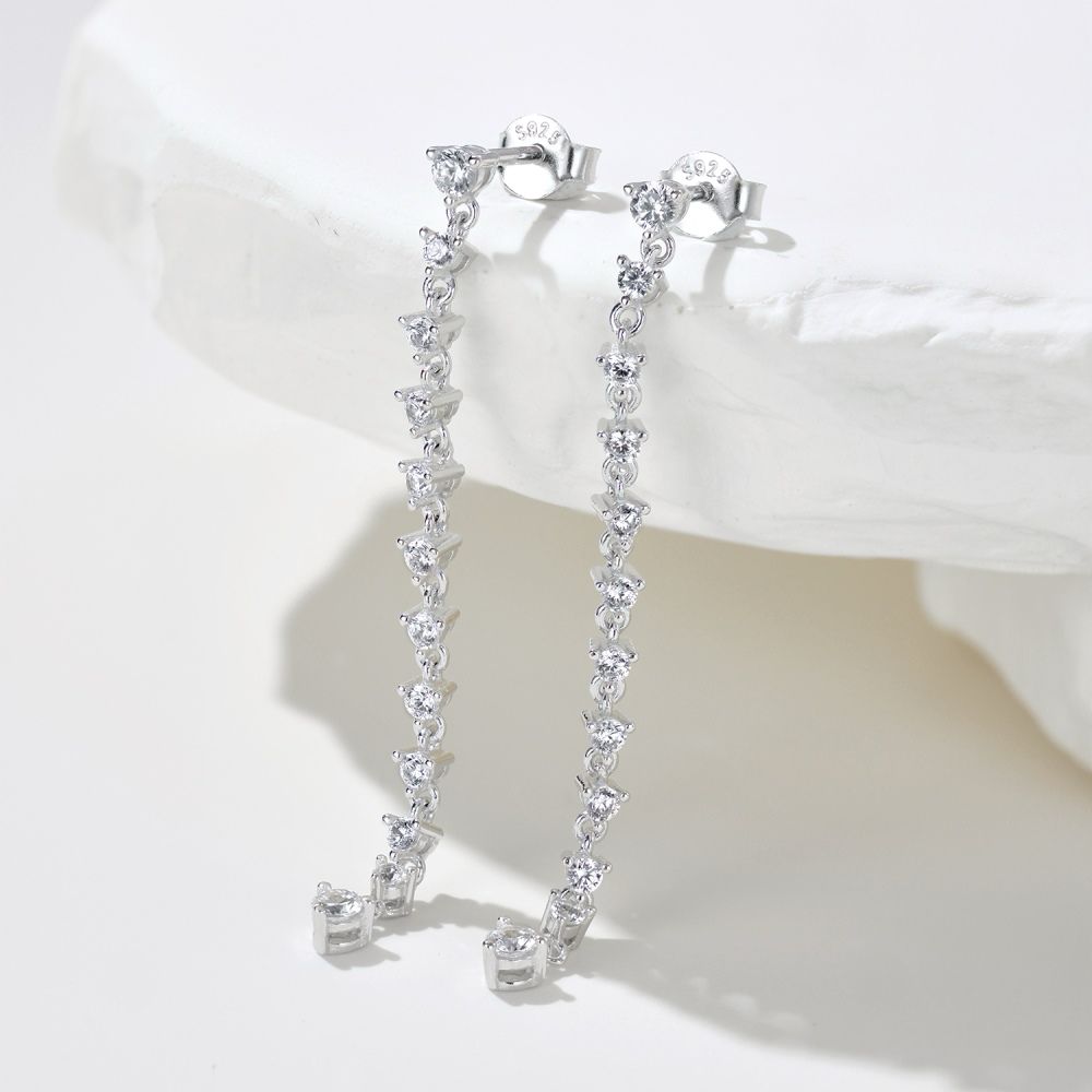 A pair of long drop earrings featuring a series of clear cubic zirconia stones set in sterling silver.