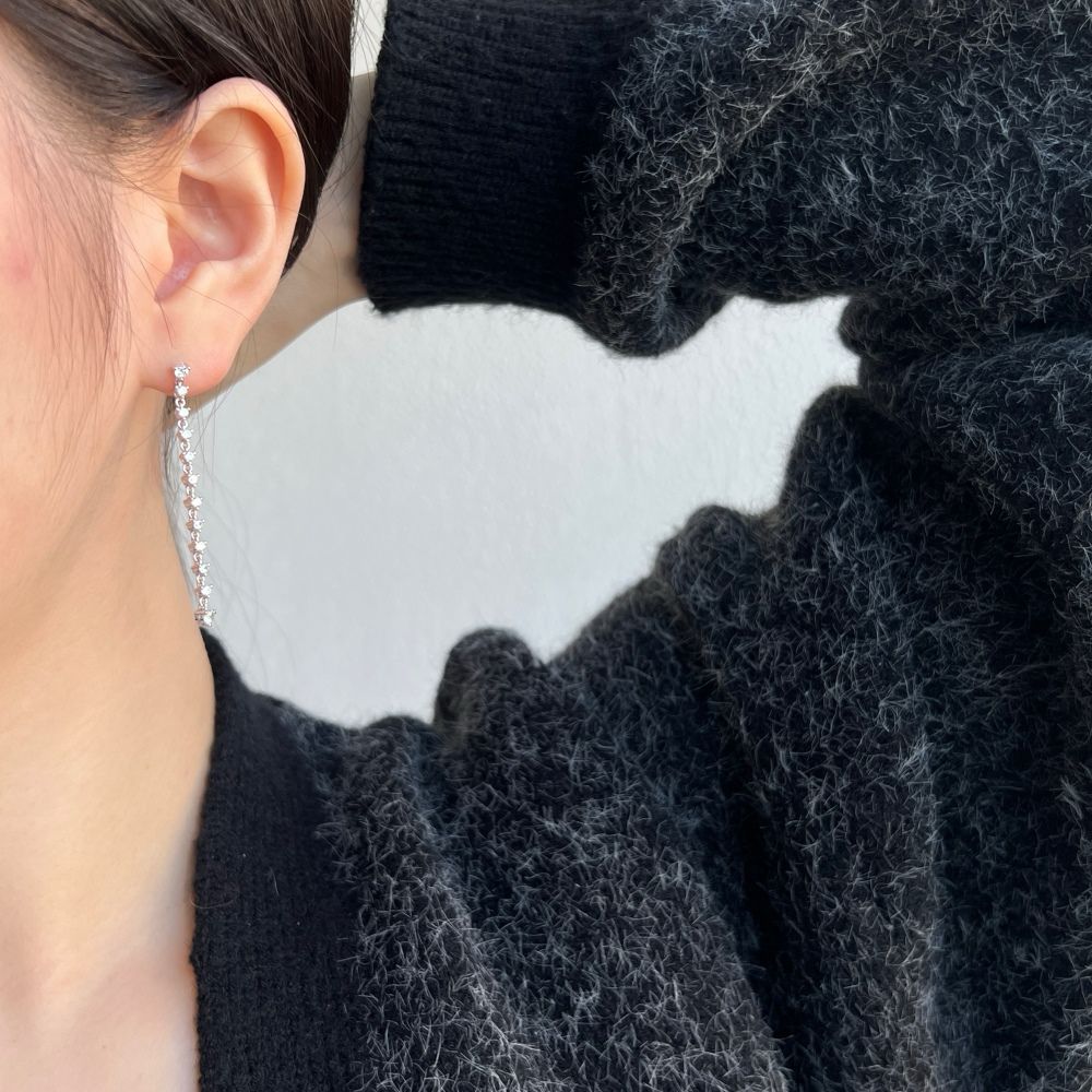 A long drop earring featuring a series of clear cubic zirconia stones set in sterling silver.