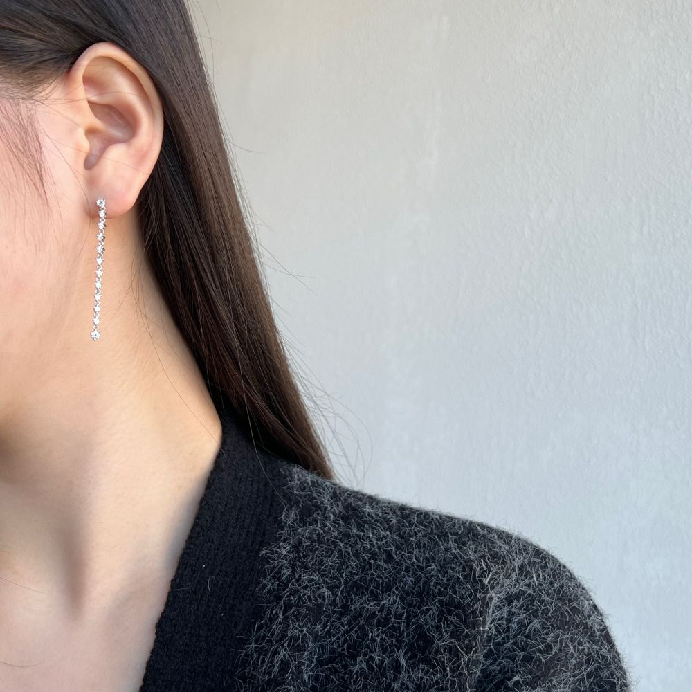 A long drop earring featuring a series of clear cubic zirconia stones set in sterling silver.