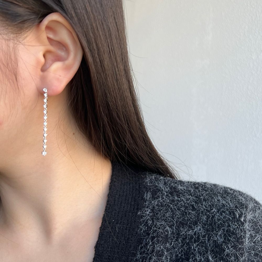 A long drop earring featuring a series of clear cubic zirconia stones set in sterling silver.