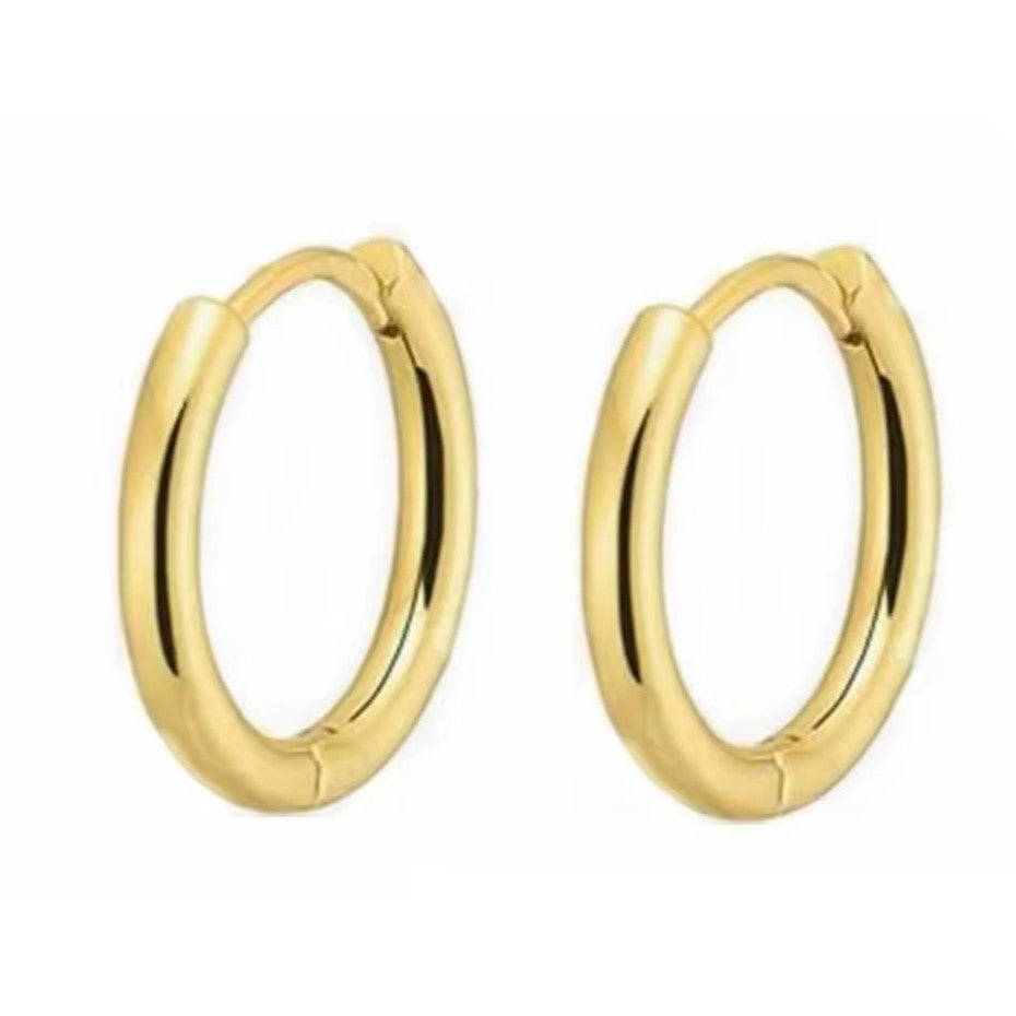 A pair of gold-colored huggie hoop earrings made of stainless steel.