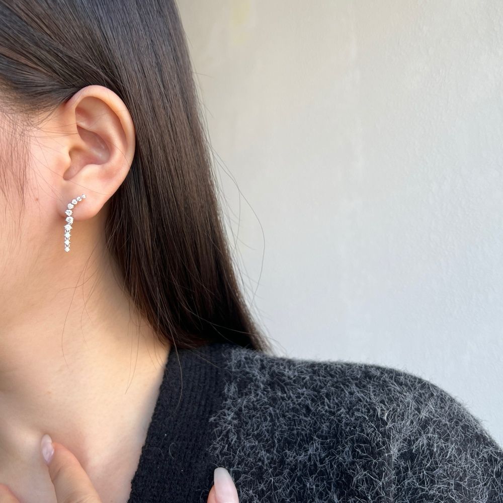 A sophisticated drop earring featuring a series of cubic zirconia stones set in a hoop design, crafted from 925 Sterling Silver.