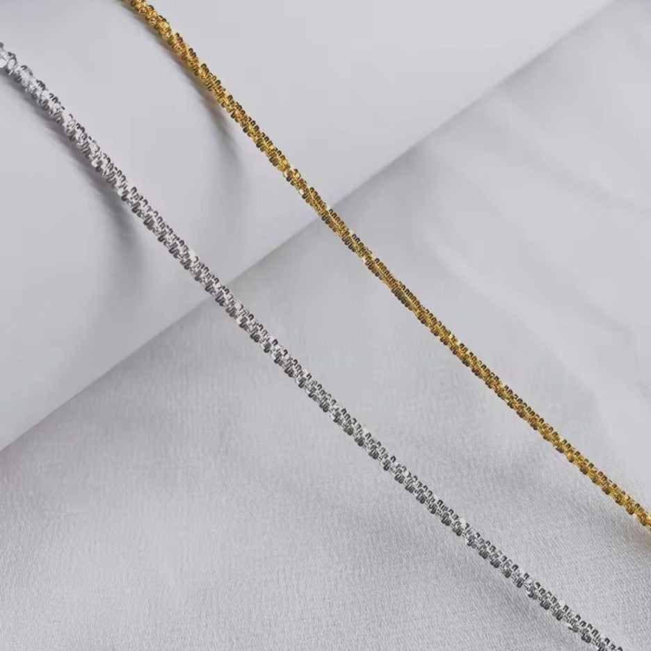Silver & Gold Spiral Chain Bracelet on white textured background