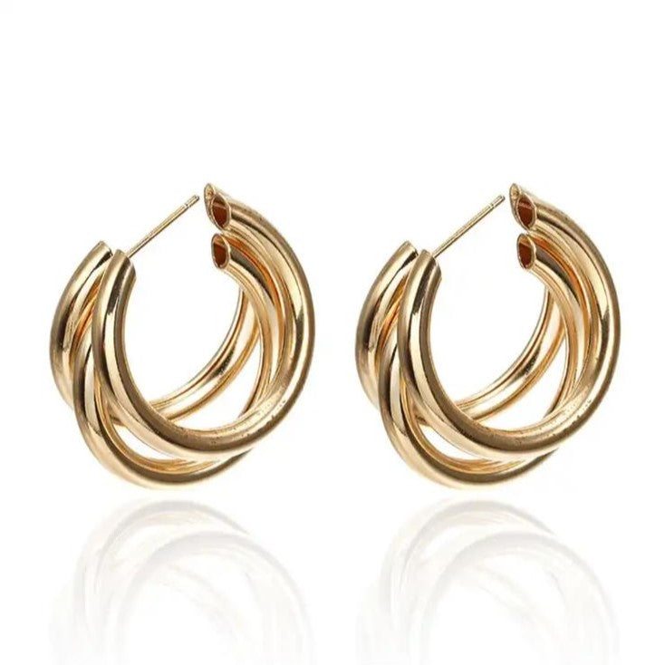 A pair of gold-colored stainless steel hoop earrings with three interlinked rings.