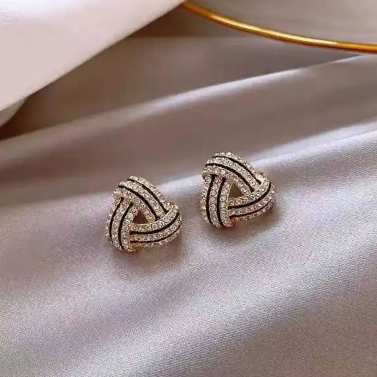 A pair of gold-colored Zara stud earrings with a geometric raised texture design.